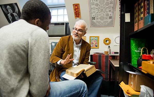 Faculty member speaking with a male student in his office