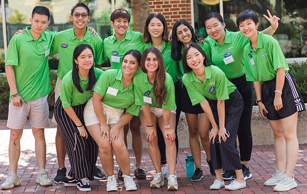 Group of 11 male and female international student orientation leaders in signature green shirts