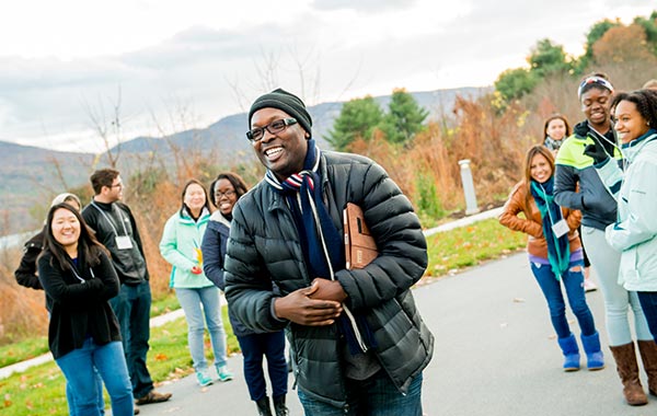 Program leader with a group of international students at a lake in the mountains