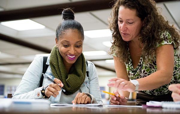 Two women doing coursework at a desk