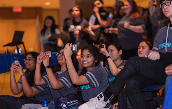 Audience members taking photos of performer at We Are The World